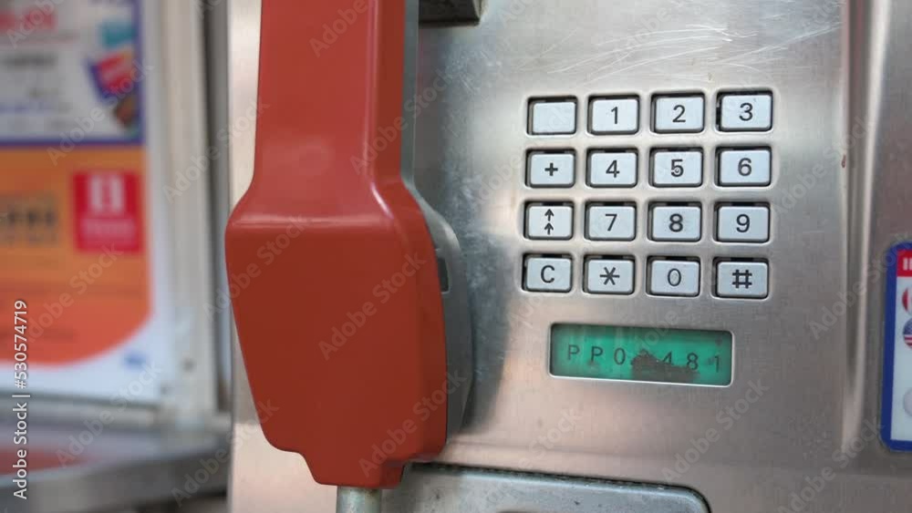 A public telephone booth, also called a payphone, with a red telephone receiver and touch-tone keypad dial is rapidly dying out and disappearing in the age of smartphones and the internet. A public telephone booth, also called a payphone, with a red telephone receiver and touch-tone keypad dial is rapidly dying out and disappearing in the age of smartphones and the internet.