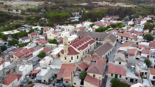 Aerial drone footage of traditional countryside valley village Omodos, in Limassol, Cyprus. 360 view of Timios Stavros (Holy Cross) monastery, tiled roof architecture and narrow streets from above.