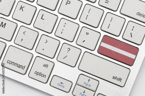 national flag of latvia on the keyboard on a grey background .3d illustration