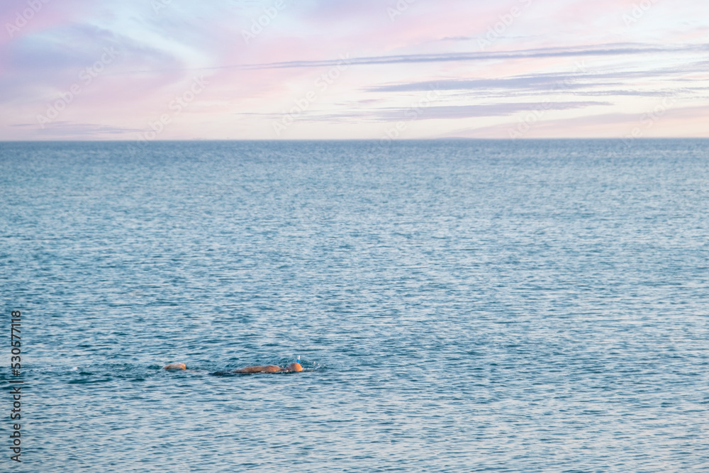 the only man swimming in the calm and calm sea. Selective Focus swimmer. the only man swimming in the calm and calm sea. Selective Focus swimmer.