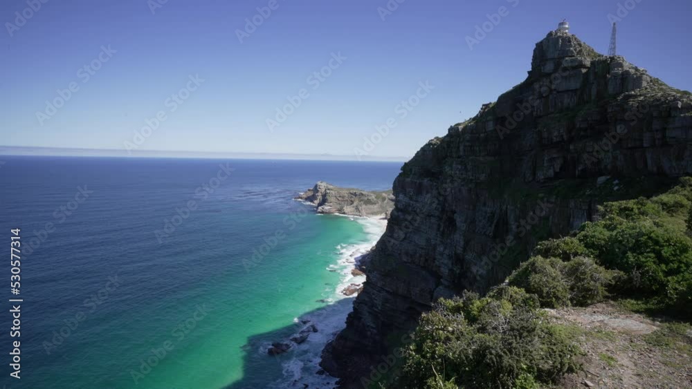 A panoramic view of Cape Point lighthouse on top of Dias Rock with the ocean and Dias beach below.