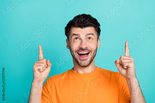 Closeup photo of young handsome bearded funny guy face open mouth excited good mood fingers pointing empty space look interested isolated on cyan color background