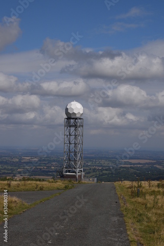 a view of the radar station at Titterstone Clee summit with the sky clear blue with fluffy clouds photo