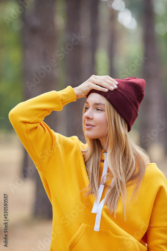 Closeup portrait of gorgeous young blonde Caucasian woman in knitted beanie in autumn in park. Young woman head shot, natural light