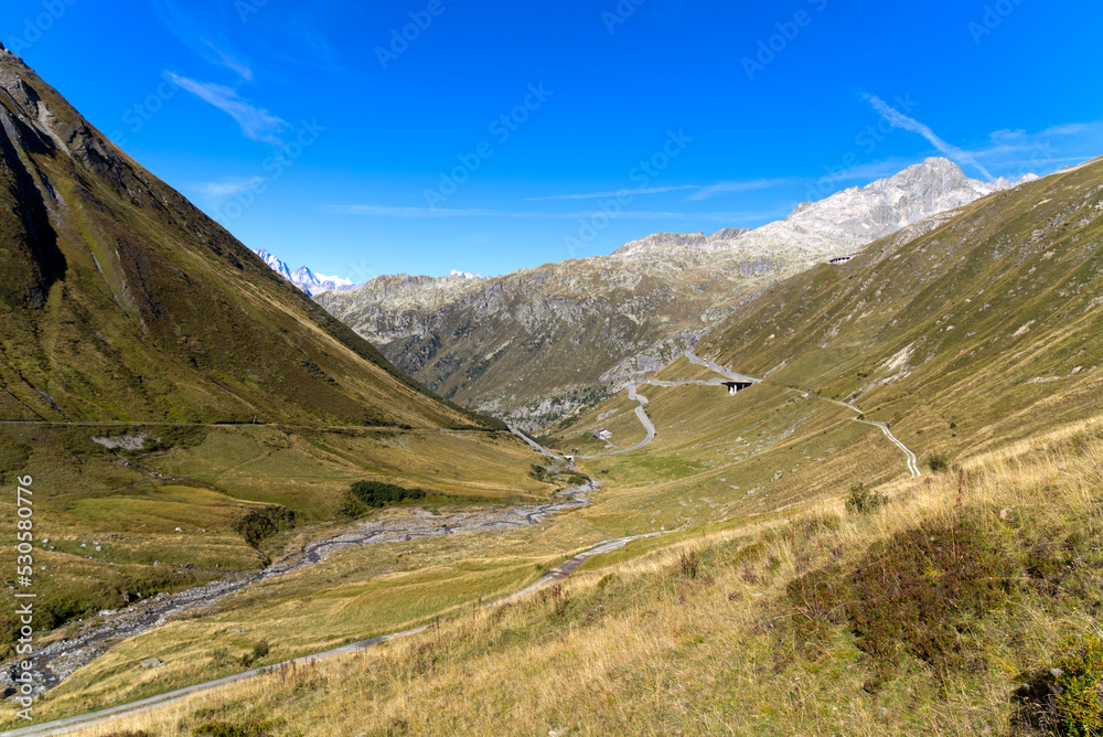 Impressive panoramic landscape in the Swiss Alps with peaks at region of Swiss mountain pass Furkapass on a sunny late summer morning. Photo taken September 12th, 2022, Furka Pass, Switzerland.