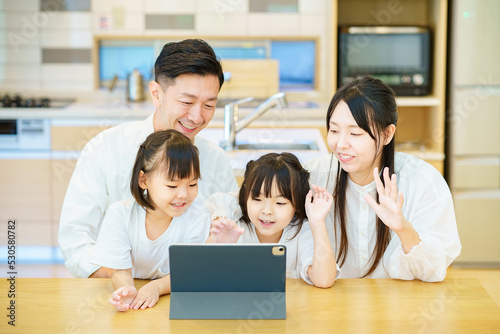 タブレットPCの画面を見る親子