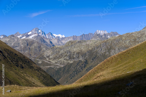 Impressive panoramic landscape in the Swiss Alps with peaks at region of Swiss mountain pass Furkapass on a sunny late summer morning. Photo taken September 12th, 2022, Furka Pass, Switzerland. photo