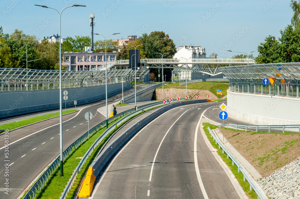 End of new city highway Trasa Lagiewnicka in Krakow, Poland, with slip roads, noise barriers, viaduct for pedestrians and bikes