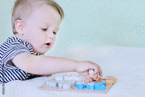 Defocused child playing with 3D wooden puzzle toys at home. Copy space - concept of early childhood development, intelligence, fun games, skill acquisition, education, family learning, preschool