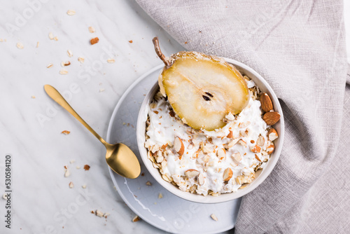 Obraz na płótnie The candied pear in oatmeal with almonds and milk. It's a perfect breakfast. w salonie