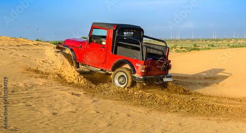 Red Suv Doing Drift in Rajasthan Jaisalmer Desert, India. Selective focus is used.