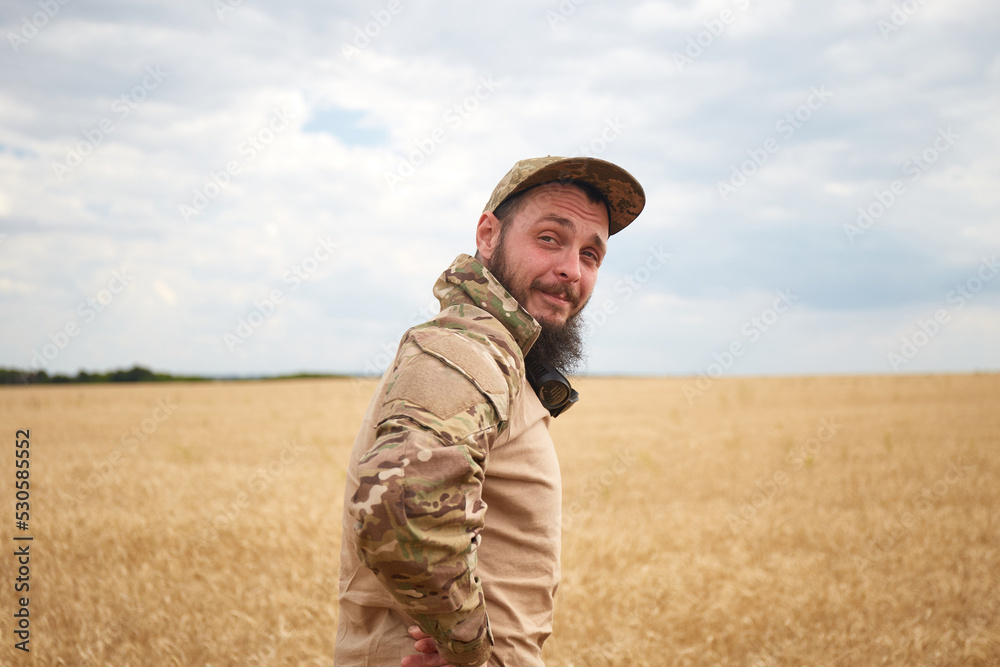 Ukrainian military man in wheat field. Ukrainian wheat fields and war upcoming food crisis. Armed Forces of Ukraine