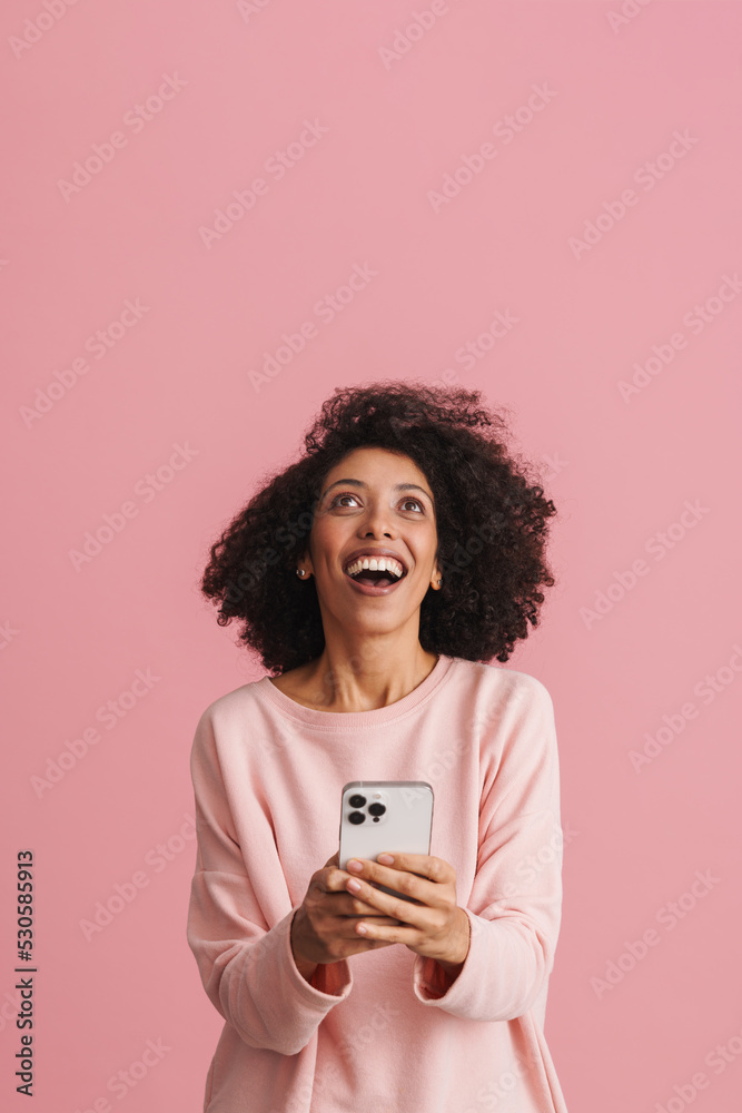 Black young woman laughing while using mobile phone Black young woman laughing while using mobile phone