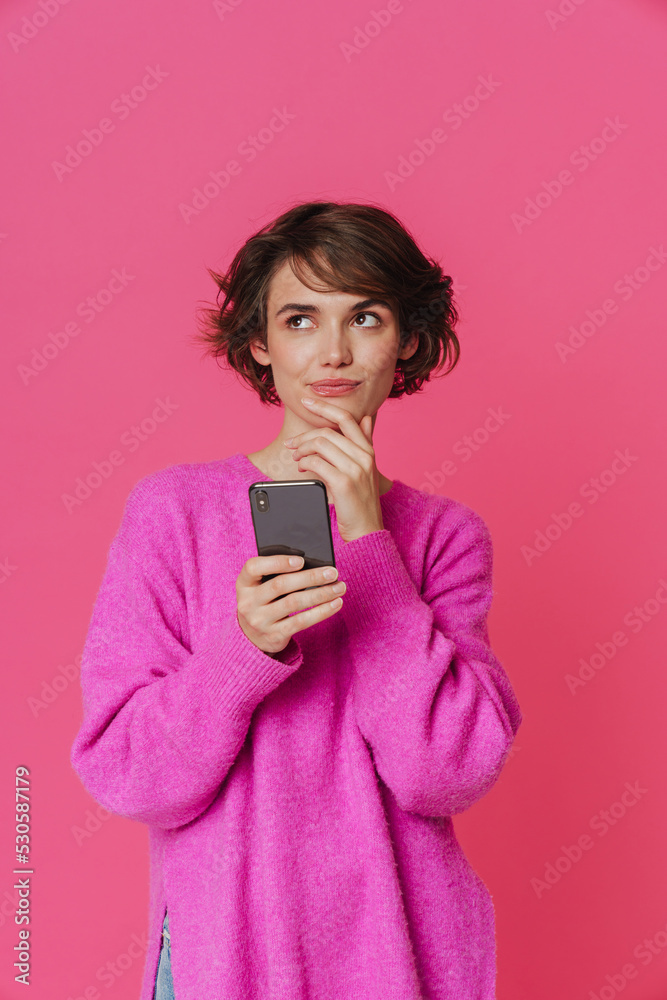 Young puzzled woman frowning while using mobile phone Young puzzled woman frowning while using mobile phone