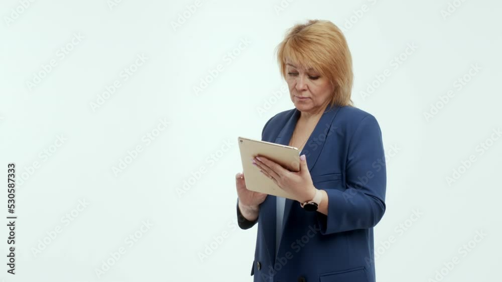 Mature businesswoman using tablet computer in fashion business startup studio. Portrait of a woman holding a digital tablet and smiling at the camera. Elegant senior woman holding digital tablet. Mature businesswoman using tablet computer in fashion business startup studio. Portrait of a woman holding a digital tablet and smiling at the camera. Elegant senior woman holding digital tablet.