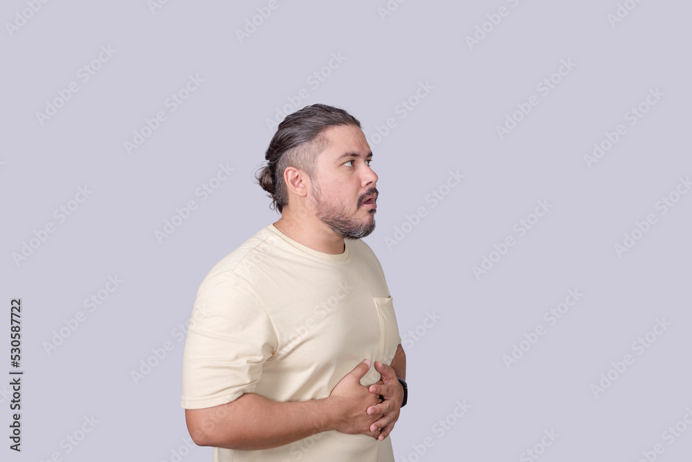 A man in his 30s experiences uncomfortable abdominal cramping, stomachache, or just belching. - obrazy, fototapety, plakaty 