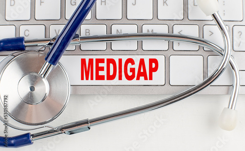 MEDIGAP text on keyboard with stethoscope , medical concept photo