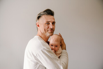 Mid white father smiling while spending time with her baby