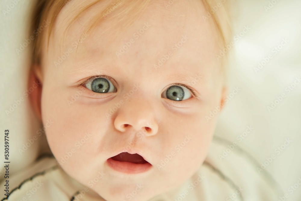 Little newborn baby girl lying in white clothes on white background. Little newborn baby girl lying in white clothes on white background.