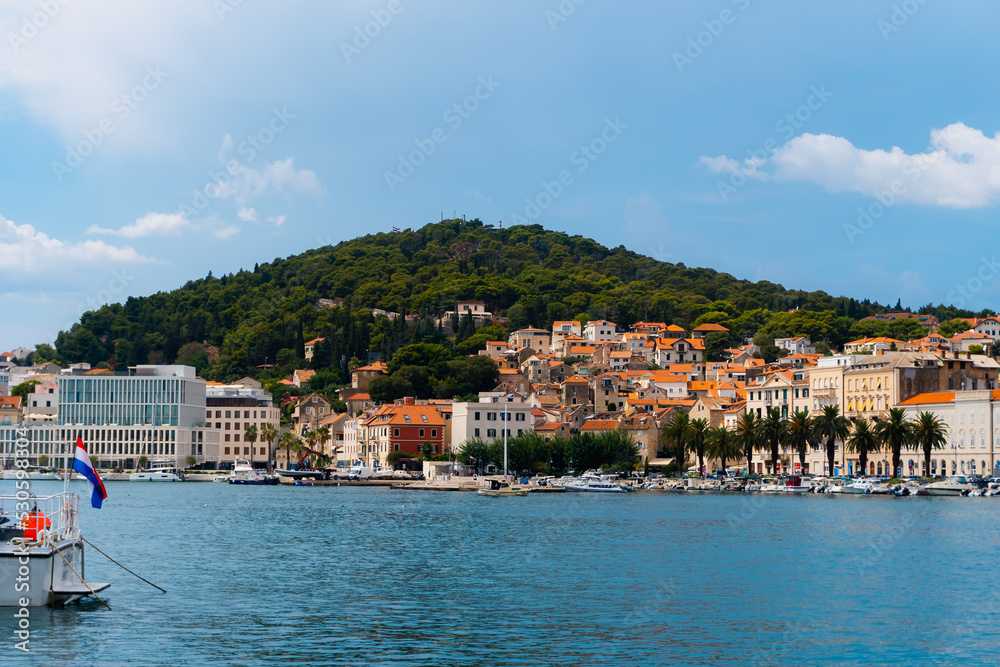 Obraz premium beautiful town with a hill in the background and a promenade with palm trees and boats in Split, Croatia