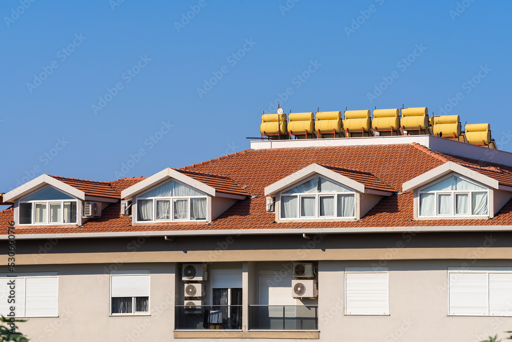 The roof of an apartment building with installed solar water heaters.