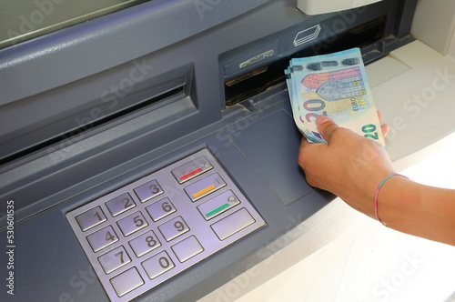 hand who withdraws money in european twenty euro banknotes in the atm automatic teller machine