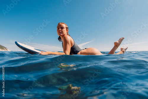 Photography Attractive surf girl on surfboard in ocean during surfing