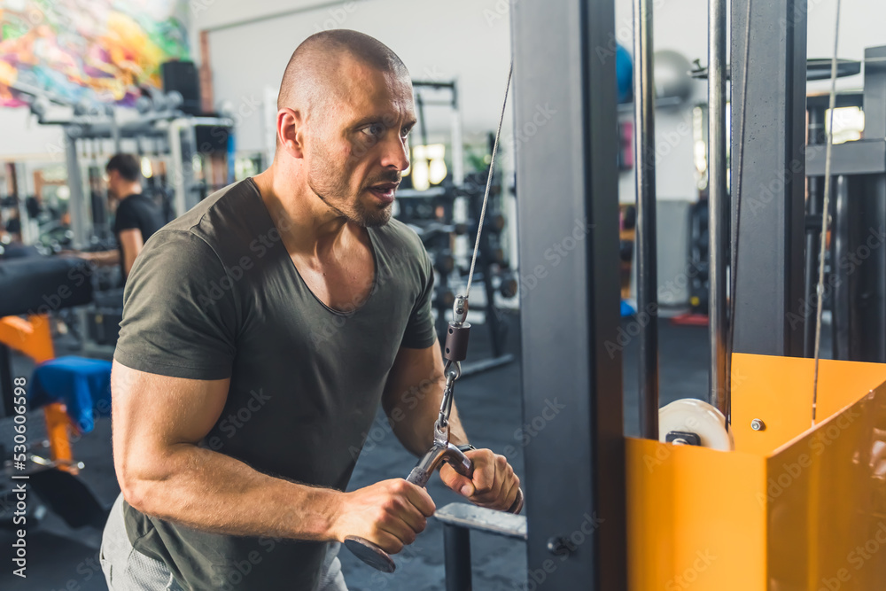 fitness young man using a rowing machine at the gym, medium shot healthy lifestyle concept. High quality photo fitness young man using a rowing machine at the gym, medium shot healthy lifestyle concept. High quality photo