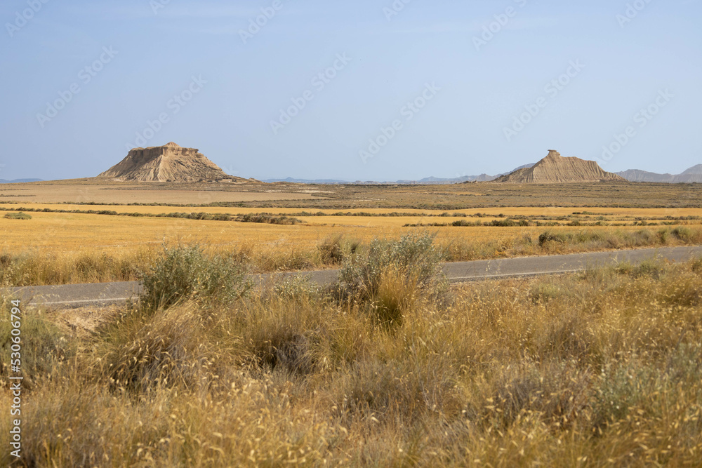 Wide arid golden desert, off road, with extreme heat and very textured, in Bardenas Reales, Navarra, Spain