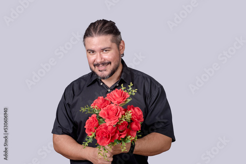 Bilde på lerret A stocky bearded man in a black polo shirt holding a bouquet of red roses