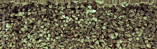 Aufgstapeltes Brennholz vor einer Holzwand