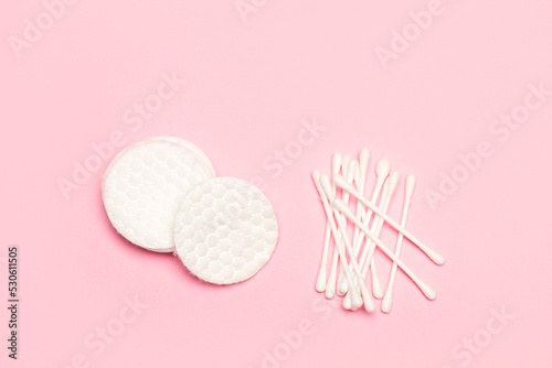 Discos almohadillas de algodón blanco y bastoncillos de algodón sobre un fondo rosa pastel liso y aislado. Vista superior y de cerca. Copy space photo