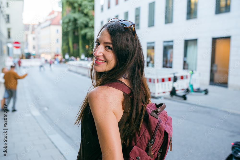 Young woman carrying a backpack in the city