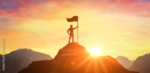 Fototapeta Silhouette of businessman holding flag on top mountain, sky and sun light background