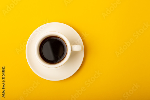 Aromatic coffee in a cup on a yellow background.Espresso. Morning drink. Cheerful morning concept. Place for text. Place to copy.
