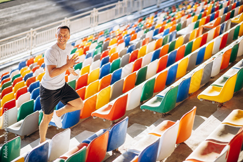 Young sporty man running up the stairs at the stadium