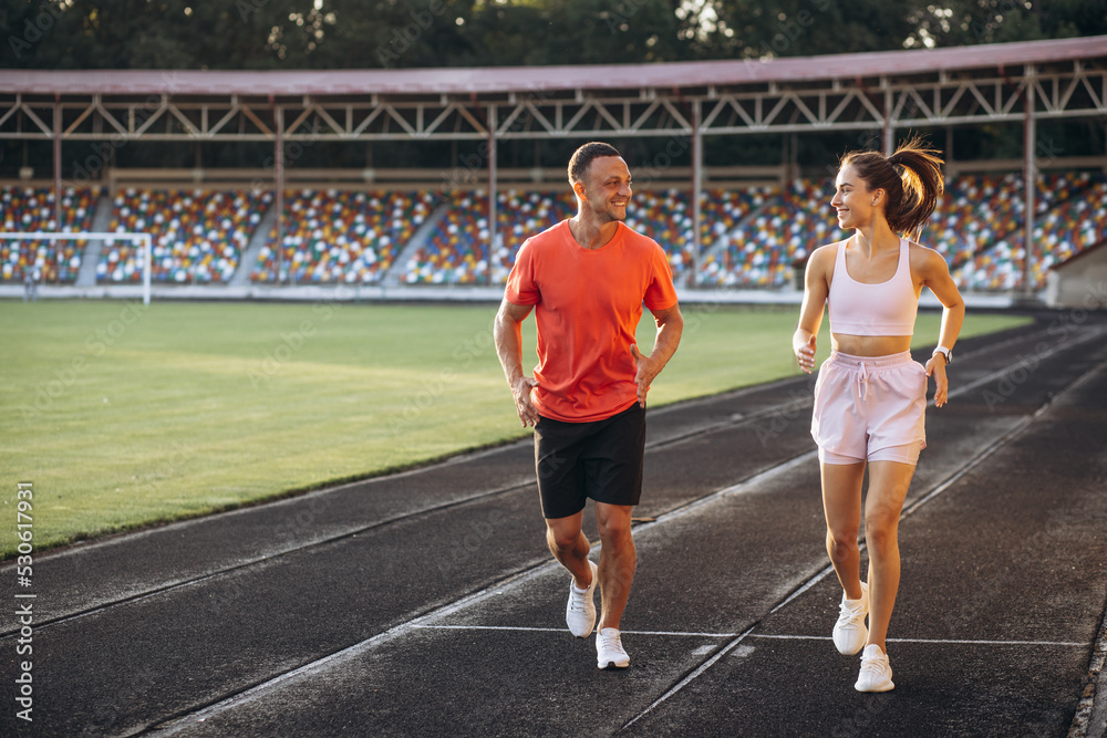 Couple running on the track at stadium