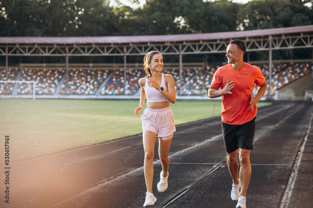 Fototapeta premium Couple running on the track at stadium