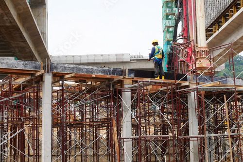 MELAKA  MALAYSIA - JUNE 5  2022  Construction workers work at height and wear safety gear to ensure their safety. They work in groups and carry out their specific tasks.