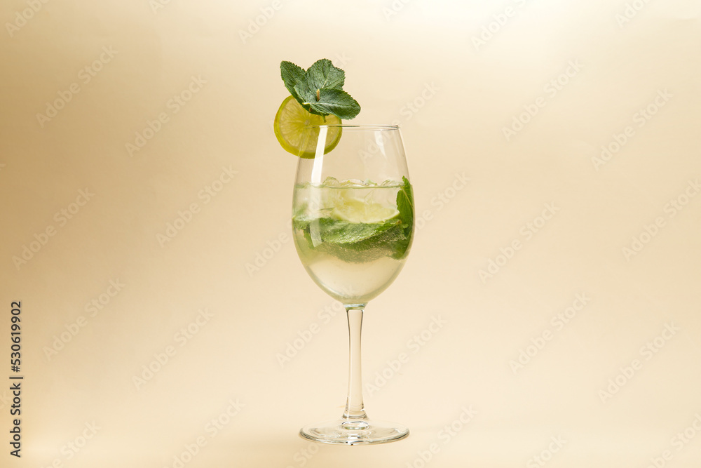 glass of mojito cocktail on brown background.