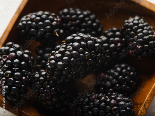 Blackberries in a wooden bowl. Close-up. There are no people in the photo. Banner, advertising. Cooking - recipe book, culinary blog. Background, wallpaper, texture.