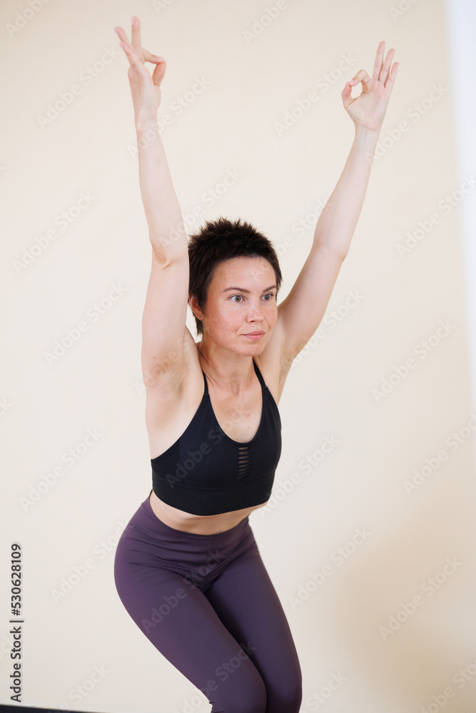 Young pretty yoga girl portrait, doing yoga poses indoors. Beautiful brunette short-haired woman doing pilates exercises. Woman in sports suit meditating. Woman stretching alone, flexible and slim. Young pretty yoga girl portrait, doing yoga poses indoors. Beautiful brunette short-haired woman doing pilates exercises. Woman in sports suit meditating. Woman stretching alone, flexible and slim.