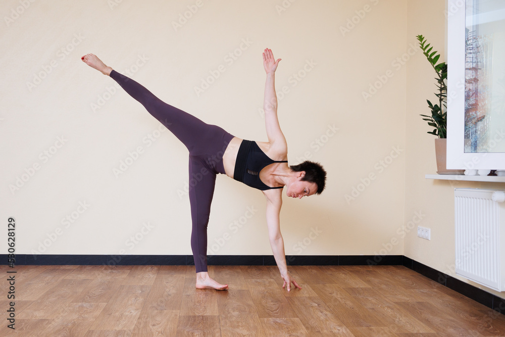 Young pretty yoga girl portrait, doing yoga poses indoors. Beautiful brunette short-haired woman doing pilates exercises. Woman in sports suit meditating. Woman stretching alone, flexible and slim. Young pretty yoga girl portrait, doing yoga poses indoors. Beautiful brunette short-haired woman doing pilates exercises. Woman in sports suit meditating. Woman stretching alone, flexible and slim.