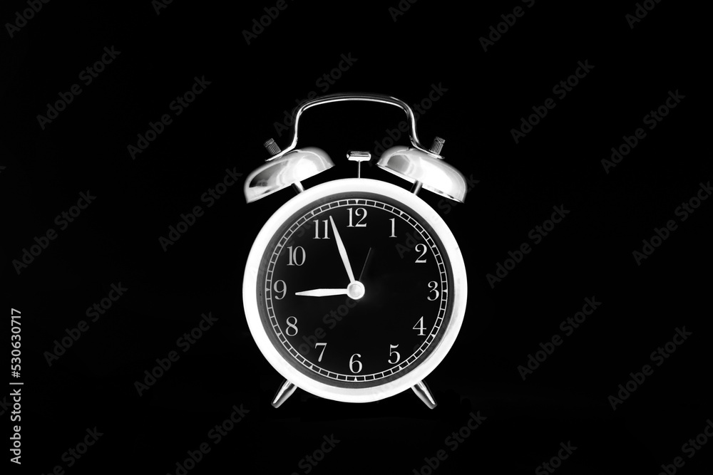 White alarm clock isolated on black background. 9 o'clock. Morning, reminder. Time concept. Shot in inversion mode White alarm clock isolated on black background. 9 o'clock. Morning, reminder. Time concept. Shot in inversion mode