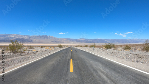 State Route 190 crossing Panamint Valley in Death Valley National Park  California  United States. Empty desert road in Death Valley with clear blue sky.