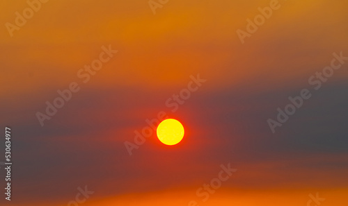 Clouds and sun in the yellow sky. Beautiful summer sunset