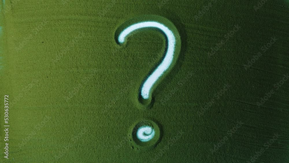 Question Mark Suign Hand drawing Question Mark Symbol in the Green Sand. Male hand writes a ...