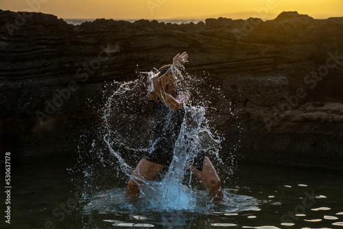 middle-aged woman dancing and throwing water in the air, Maioris beach, llucmajor, Majorca, Balearic Islands, Spain