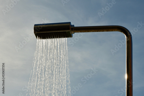 Outdoor rain shower with water running outside backlit by evening sun in Madrid, Spain