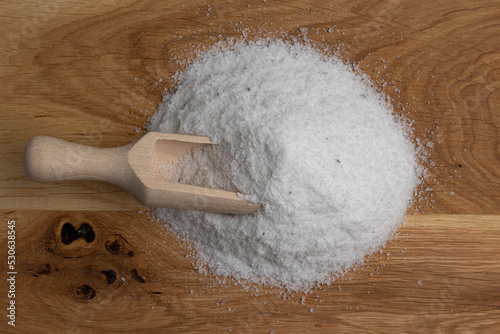 salt in wooden scoop isolated on wooden background